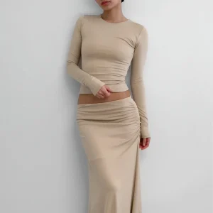 Cinco faldas largas de punto, fruncidas en la cintura, en colores beige, negro, gris, bordó y marrón, dispuestas horizontalmente.