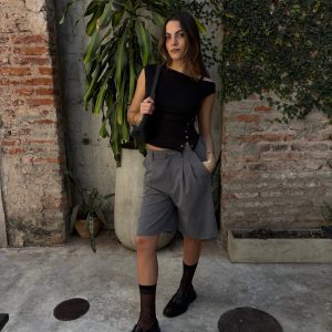 odelo usando bermuda sastrera crop gris de tiro alto con top negro y medias de red