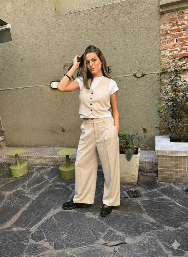 Pantalón sastrero de lino color beige o natural, de corte wide leg (pierna ancha), tiro alto y detalles de pinzas. Ideal para un look elegante y relajado.