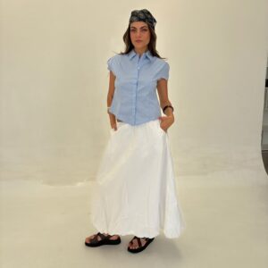 Camisa de poplin liso, manga corta, color liso (ej. negro/blanco). Diseño entallado con pinzas en los hombros.