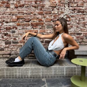 Top Sunset ajustado, con escote halter alto, abertura profunda en el centro del pecho y confeccionado en tejido texturizado o con brillo sutil. Disponible en blanco y negro.