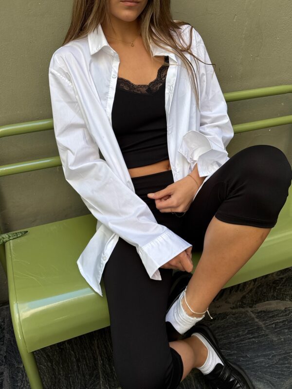 Camisa básica de corte oversize y manga larga, de tela de popelina o algodón, ideal para layering. Disponible en blanco y negro.