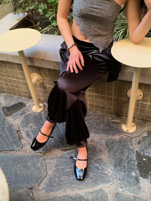 Babucha de satén brillante en tono oscuro (negro/marrón), con cintura elástica y caída fluida. Ideal para un look elegante y cómodo.