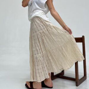Falda Orion maxi beige, plisada y arrugada con brillos sutiles. Falda larga de volados para un estilo bohemio.