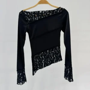 Top negro de mujer con recortes asimétricos y diseño cut-out.